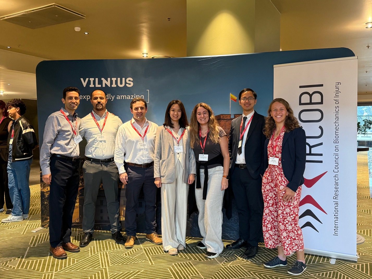 The HEAD Lab group in front of the IRCOBI and Vilnius banners at the 2025 conference.