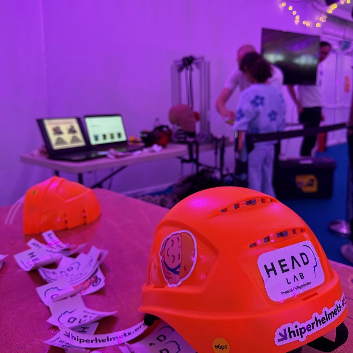 Orange HIPER-rated helmets and HEAD Lab stickers on the lab’s outreach stand.